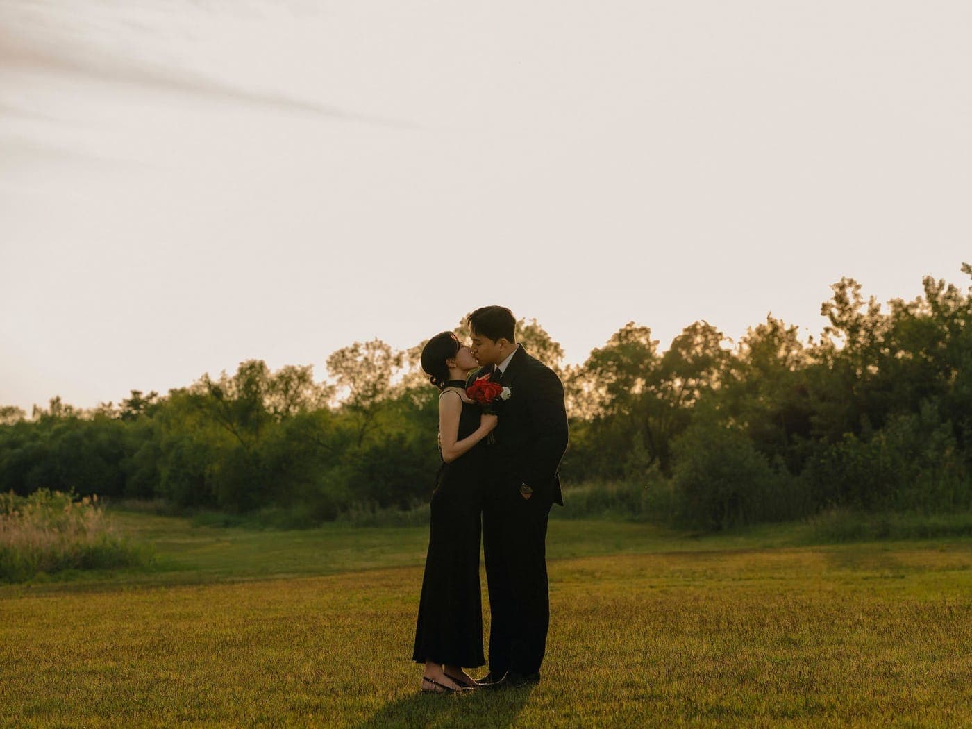노을빛 들판에서 입맞추는 신랑과 신부